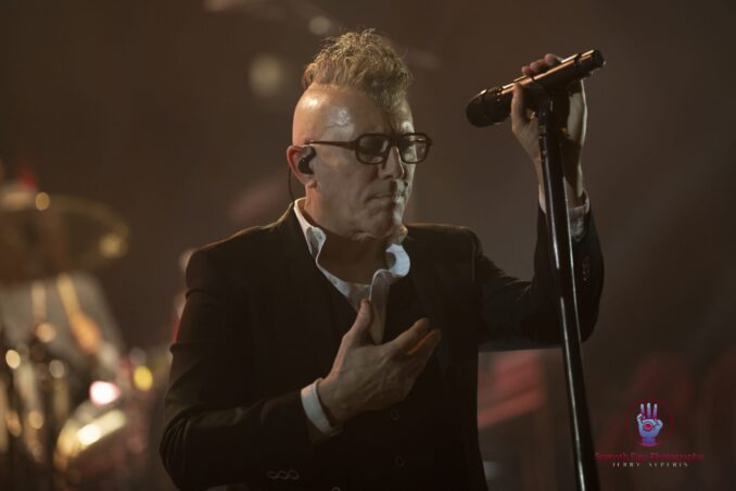 Maynard James Keenan on stage with a microphone.